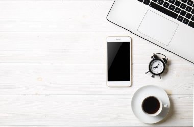 Blogger / işadamı / işkadını, bu dizüstü bilgisayar, boş ekran smartphone, kahve fincanı ve malzemeleri ile uzman'ın beyaz ahşap ofis alanı tablo. Üstten Görünüm, kopya alanı, düz lay, Tepegöz, zemin.
