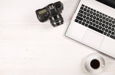 Blogger / işadamı / işkadını / fotoğrafçı, bu dizüstü bilgisayar, boş ekran, kahve fincanı ve malzemeleri ile uzman'ın beyaz ahşap ofis alanı tablo. Üstten Görünüm, kopya alanı, düz lay, Tepegöz, backdr