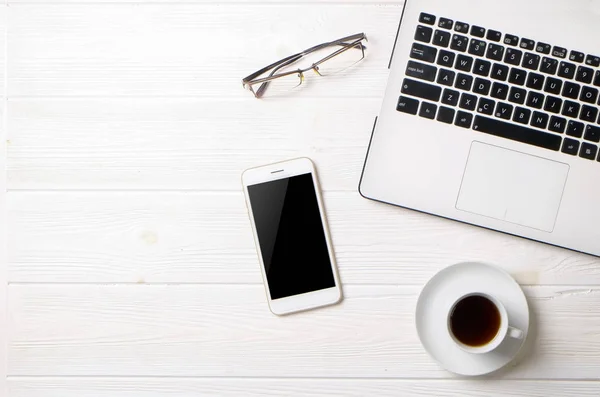 Blogger / hombre de negocios / mujer de negocios, es la mesa de espacio de oficina de madera blanca del especialista con computadora portátil, teléfono inteligente de pantalla en blanco, taza de café y suministros. Vista superior, espacio para copiar, plano, arriba, telón de fondo . — Foto de Stock