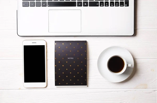 Blogger / hombre de negocios / mujer de negocios, es la mesa de espacio de oficina de madera blanca del especialista con computadora portátil, teléfono inteligente de pantalla en blanco, taza de café y suministros. Vista superior, espacio para copiar, plano, arriba, telón de fondo . — Foto de Stock