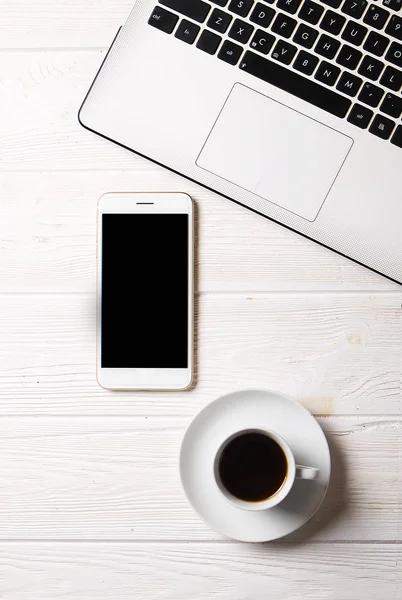 Blogger / hombre de negocios / mujer de negocios, es la mesa de espacio de oficina de madera blanca del especialista con computadora portátil, teléfono inteligente de pantalla en blanco, taza de café y suministros. Vista superior, espacio para copiar, plano, arriba, telón de fondo . — Foto de Stock