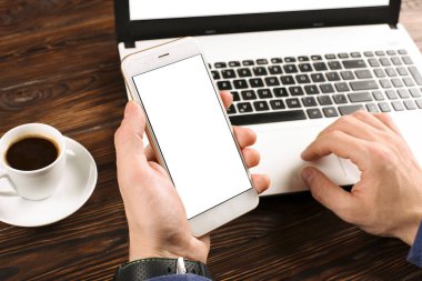 Raslantı giyimli öğrenci / blogger / yazar / man pc dizüstü bilgisayarda çalışan, klavyede yazarak, içme kafe / bar, smartphone kullanarak blog makale yazma. Çalışma alanı Ofis Masası Üstten Görünüm.