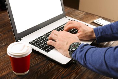Raslantı giyimli öğrenci / blogger / yazar / man pc dizüstü bilgisayarda çalışan, klavyede yazarak, içme kafe / bar, smartphone kullanarak blog makale yazma. Çalışma alanı Ofis Masası Üstten Görünüm.