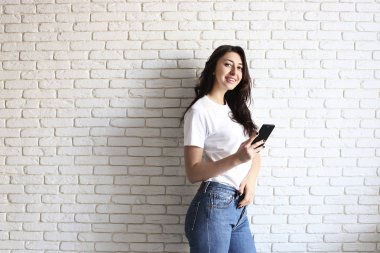 Mutlu bin yıllık kız içeride eğleniyor. Dişler arasındaki diastema boşluğu olan kadın portresi. Güzel gülümseme. Minimalist iç, beyaz tuğla duvar arka plan, loft tarzı dokulu. Kopya alanı.