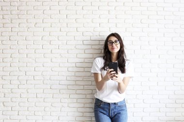 Mutlu bin yıllık kız içeride eğleniyor. Dişler arasındaki diastema boşluğu olan kadın portresi. Güzel gülümseme. Minimalist iç, beyaz tuğla duvar arka plan, loft tarzı dokulu. Kopya alanı.