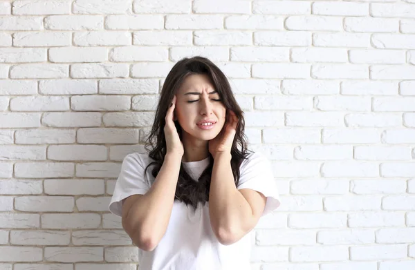 Ritratto di una bella ragazza con viso distorto e dolorante da forte emicrania. Gap tra i denti. Donna infelice che soffre di forti dolori alla testa ripetuti. Chiudi, copia spazio, sfondo . — Foto Stock