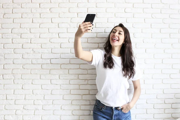 Mulher elegante fazendo selfie com saco de compras no fundo da parede amarela. Venda de férias de inverno — Fotografia de Stock