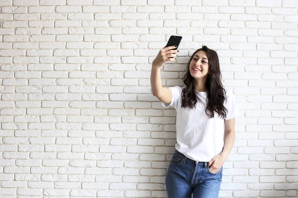 Mulher elegante fazendo selfie com saco de compras no fundo da parede amarela. Venda de férias de inverno — Fotografia de Stock