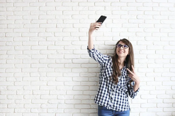 Mulher elegante fazendo selfie com saco de compras no fundo da parede amarela. Venda de férias de inverno — Fotografia de Stock