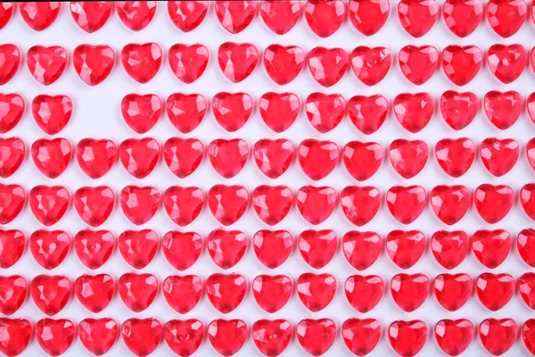 Röd rosa hjärta godis som i en rad på vit bakgrund. Älskare dag gratulationskort present. — Stockfoto