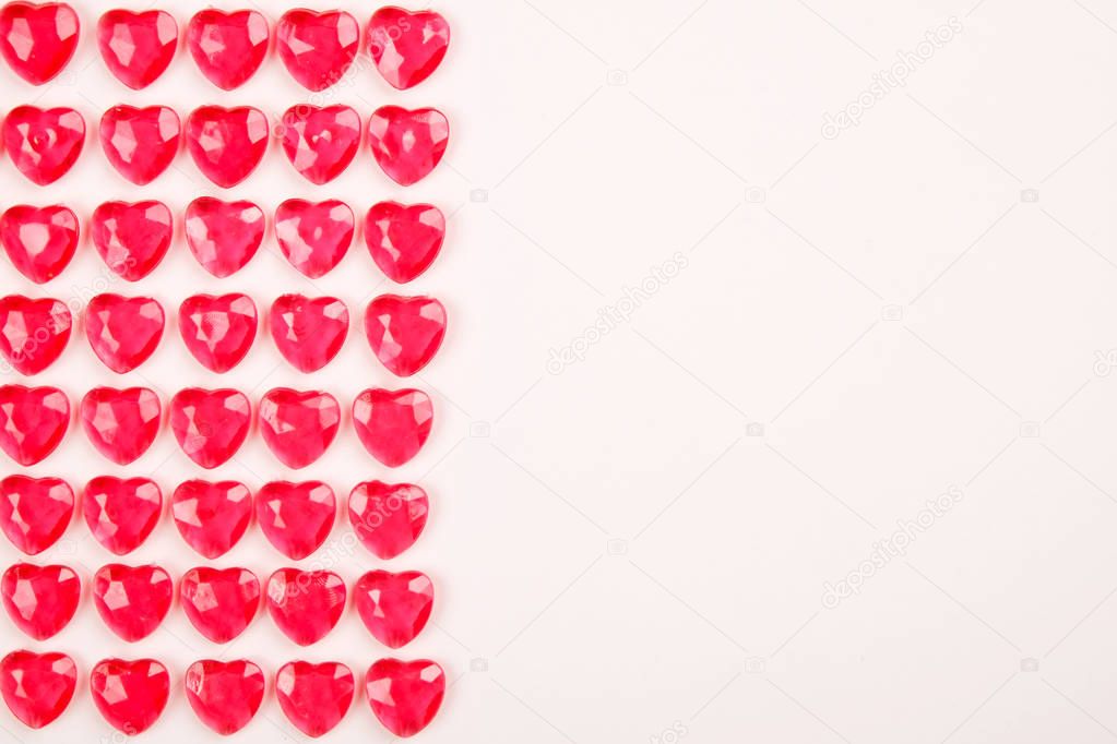 Red pink heart candies laid in a row on white background. Lovers day greeting card gift.