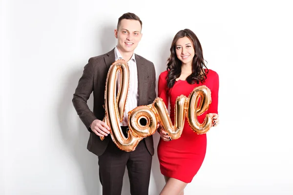 Happy Valentine\'s day photo shoot. Couple in love smiling wide, showing affection, sophisticated business casual style. 14th february, white background, copy space, front view portrait.