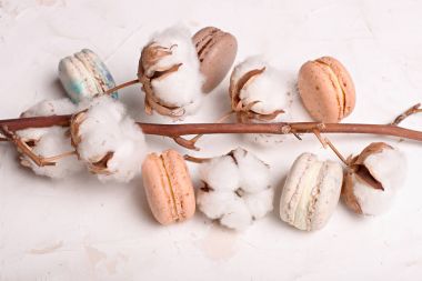 Geleneksel Fransız badem karamelli çikolata kızılcık macarons tatlı bisküvi tepside beyaz gri beton dokulu arka plan masa üstü. Lezzetli ama sağlıksız gıda.