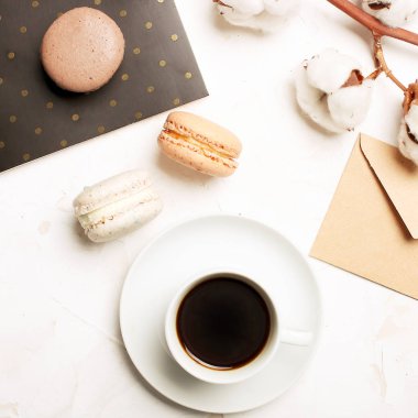 Geleneksel Fransız badem karamelli çikolata kızılcık macarons tatlı bisküvi tepside beyaz gri beton dokulu arka plan masa üstü. Lezzetli ama sağlıksız gıda.