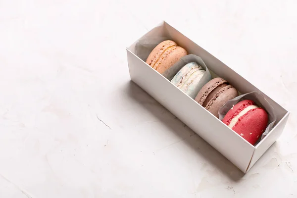 Macarrones de arándanos tradicionales de chocolate con caramelo de almendras francesas bandeja de galletas de postre sobre fondo texturizado de hormigón gris blanco. Comida sabrosa pero poco saludable . —  Fotos de Stock