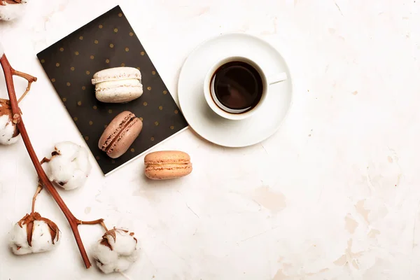 Geleneksel Fransız badem karamelli çikolata kızılcık macarons tatlı bisküvi tepside beyaz gri beton dokulu arka plan masa üstü. Lezzetli ama sağlıksız gıda.