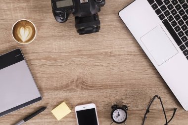 Fotoğraf blogger / fotoğrafçı / o uzman'ın tipik ofis alanı tablo dizüstü bilgisayar, boş ekran, kahve fincanı ve elektronik. Üstten Görünüm, kopya alanı, düz lay, Tepegöz, zemin.