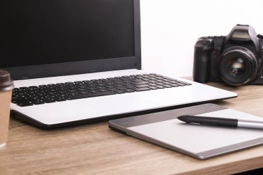 Fotoğraf blogger / fotoğrafçı / o uzman'ın tipik ofis alanı tablo dizüstü bilgisayar, boş ekran, kahve fincanı ve elektronik. Üstten Görünüm, kopya alanı, düz lay, Tepegöz, zemin.