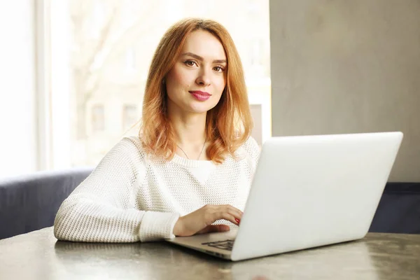 Attrayant hipster jeune femme dans le restaurant café loft café moderne. Écrivain, blogueur, designer, pigiste, processus de travail à distance. E-shopping, achats en ligne, m-shopping . — Photo