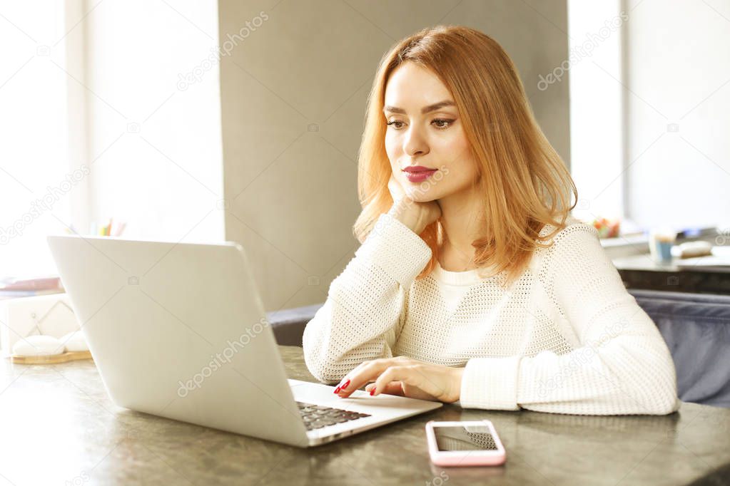 Attractive hipster young woman in modern loft cafe coffee shop restaurant. Writer, blogger, designer, freelancer, remote work process. E-shopping, online shopping, m-shopping.