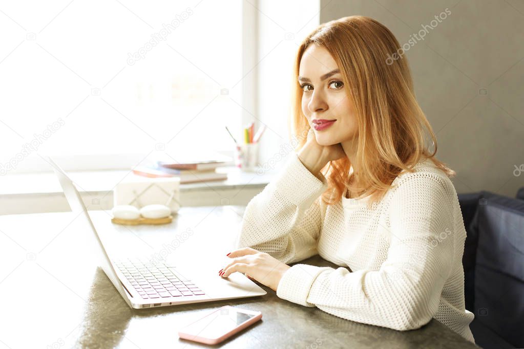 Attractive hipster young woman in modern loft cafe coffee shop restaurant. Writer, blogger, designer, freelancer, remote work process. E-shopping, online shopping, m-shopping.