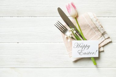 Paskalya tablo randevular, Tablo ayarı seçenekleri döşeme. Gümüş sofra öğeleri şenlikli dekorasyonu ile. Çatal, bıçak ve çiçekler. Mutlu Paskalya tatili.