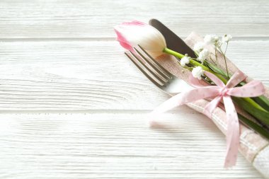 Paskalya tablo randevular, Tablo ayarı seçenekleri döşeme. Gümüş sofra öğeleri şenlikli dekorasyonu ile. Çatal, bıçak ve çiçekler. Mutlu Paskalya tatili.