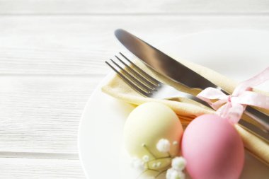 Paskalya tablo randevular, Tablo ayarı seçenekleri döşeme. Gümüş sofra öğeleri şenlikli dekorasyonu ile. Çatal, bıçak ve çiçekler. Mutlu Paskalya tatili.