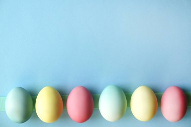 Farklı pastel renk Paskalya yumurta koydu ve beyaz kır çiçekleri ile güzel bileşiminde düzenlenmiştir. Kopya metin alanı ile tebrik kartı.