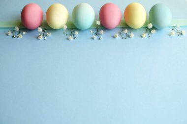 Farklı pastel renk Paskalya yumurta koydu ve beyaz kır çiçekleri ile güzel bileşiminde düzenlenmiştir. Kopya metin alanı ile tebrik kartı.