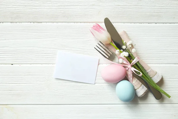 Paskalya tablo randevular, Tablo ayarı seçenekleri döşeme. Gümüş sofra öğeleri şenlikli dekorasyonu ile. Çatal, bıçak ve çiçekler. Mutlu Paskalya tatili.