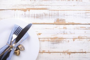 Paskalya tablo randevular, Tablo ayarı seçenekleri döşeme. Gümüş sofra öğeleri şenlikli dekorasyonu ile. Çatal, bıçak ve çiçekler. Mutlu Paskalya tatili.