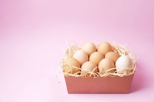 Традиционный шаблон пасхальной открытки с пастельными цветами окрашенных органических яиц в плетеную корзину с сеном и декоративными полевыми цветами
.