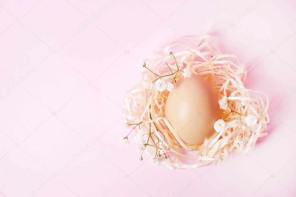 Traditional easter card template with pastel colors painted organic eggs in wicker basket with hay and decorative wildflowers.