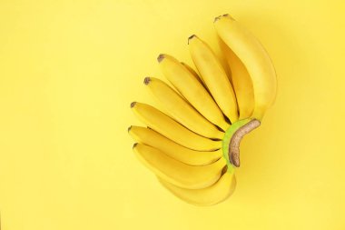 Güzel minimlistic düz yatıyordu olgun taze organik muz ile kompozisyon el sıcak sarı renkte. Görünüm kopya alanı en çok, yakın çekim.