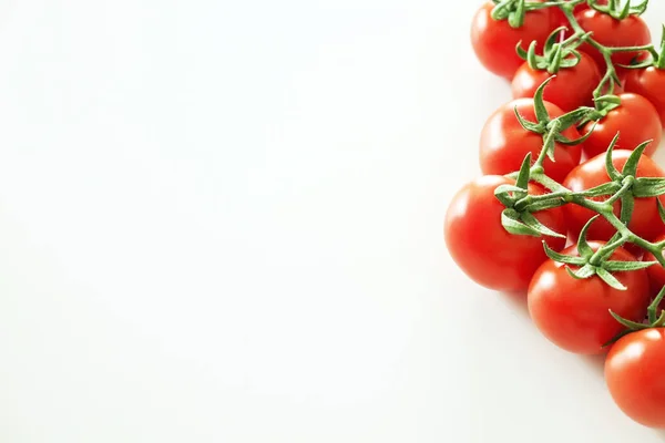 Composição de leigos planos minimalistas de tomates cereja vermelho brilhante refletindo a luz, colocando no topo da mesa branca sólida . — Fotografia de Stock