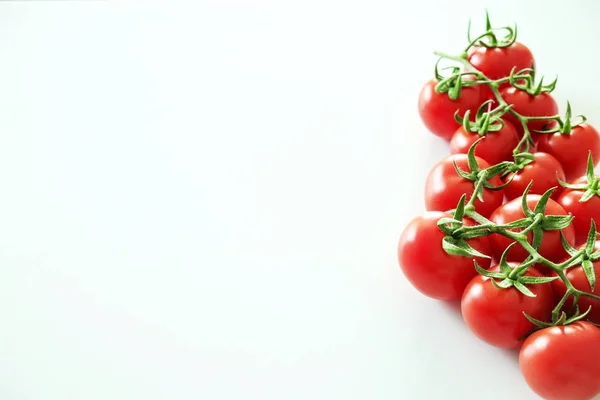 Composição de leigos planos minimalistas de tomates cereja vermelho brilhante refletindo a luz, colocando no topo da mesa branca sólida . — Fotografia de Stock