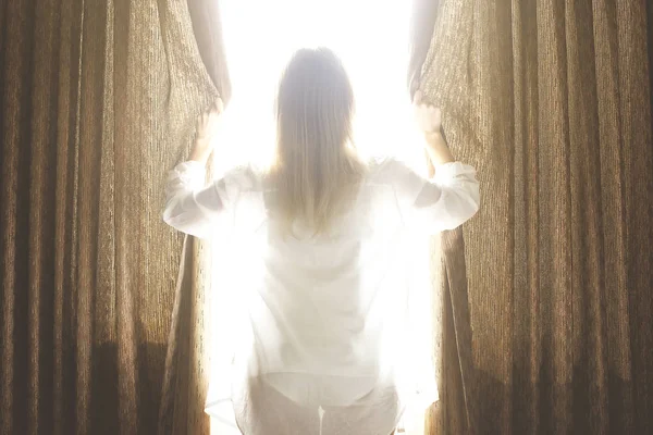 Grande quarto de hotel espaçoso cheio de luz solar e raios de sol. Início otimista do dia. Mulher loira aconchegante casa roupas acolhedoras a luz do dia da manhã. Novo dia novo eu conceito . — Fotografia de Stock