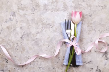 Paskalya tablo randevular, Tablo ayarı seçenekleri döşeme. Gümüş sofra öğeleri şenlikli dekorasyonu ile. Çatal, bıçak ve çiçekler. Mutlu Paskalya tatili.