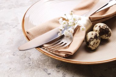 Paskalya tablo randevular, Tablo ayarı seçenekleri döşeme. Gümüş sofra öğeleri şenlikli dekorasyonu ile. Çatal, bıçak ve çiçekler. Mutlu Paskalya tatili.