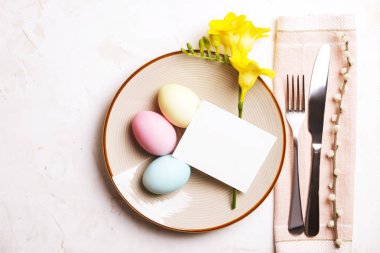 Paskalya tablo randevular, Tablo ayarı seçenekleri döşeme. Gümüş sofra öğeleri şenlikli dekorasyonu ile. Çatal, bıçak ve çiçekler. Mutlu Paskalya tatili.