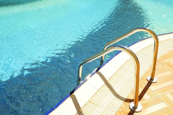 Schwimmbadbereich einer neuen Luxus-Wohnanlage mit Fliesen, verchromten Treppengriffen und Abflüssen. sonniger schöner Tag. — Stockfoto