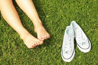 Kadın çıplak ayak mawed çim çimen üzerinde. Genç kadın açık havada barefoot, dinlenme almak bir mola kavram. Öğrenci üniversite kampüs bahçesinde üzerinde.