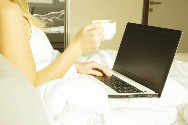 Big spacey hotel room full of sunlight and sun beams. Optimistic start of the day. Blond woman cozy home clothing welcoming the morning daylight. New day new me concept. — Stock Photo, Image