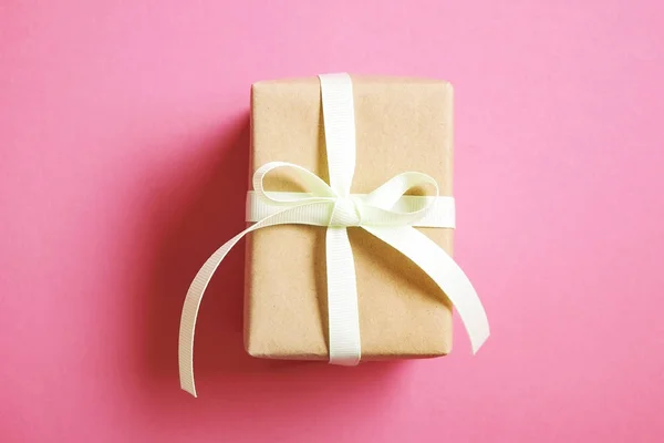 Rustieke samenstelling met mooie heden in ambachtelijke papier verpakking. Close up van de gift van de verjaardag in bruin wrap met lint en boog. — Stockfoto
