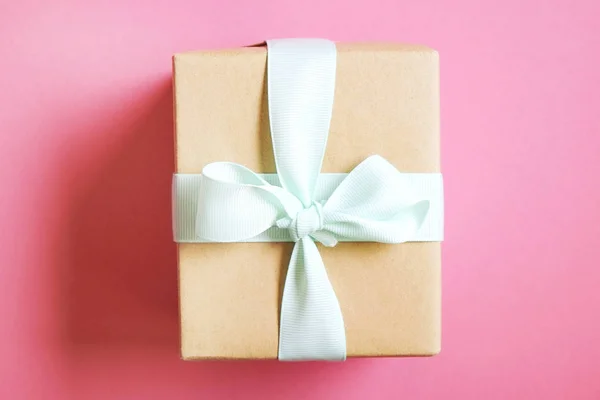 Сельский состав с красивым подарком в ручной упаковке бумаги. Закрыть подарок на день рождения в коричневой упаковке с лентой и луком . — стоковое фото