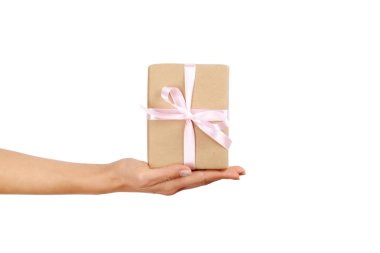 Doğum günü hediyesi vintage craft kağıt ambalaj içinde tutan eller, yakın çekim. Şimdiki zamanda kadının kolları ile Femenine kompozisyon.