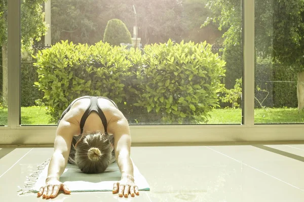 Yogi woman does yoga exercises, working out, practicing pranayam