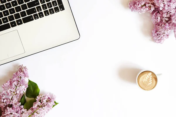 Vista superior del escritorio de la trabajadora con el ordenador portátil, flores y diferentes artículos de oficina. Espacio de trabajo femenino de diseño creativo . —  Fotos de Stock