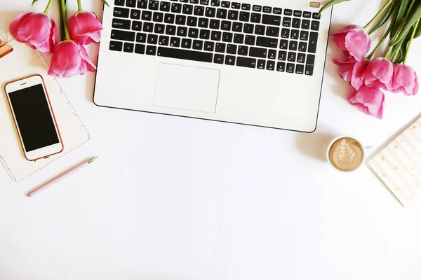 Vista dall'alto del desktop operaio femminile con laptop, fiori e diversi articoli di forniture per ufficio. Spazio di lavoro di progettazione creativa femminile . — Foto Stock
